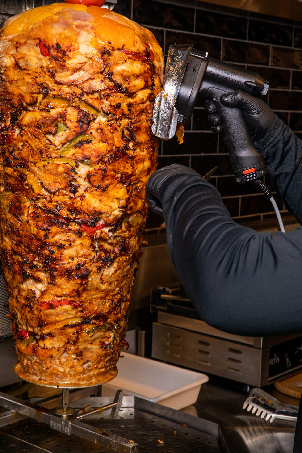 Chicken doner being carved fresh from the vertical spit