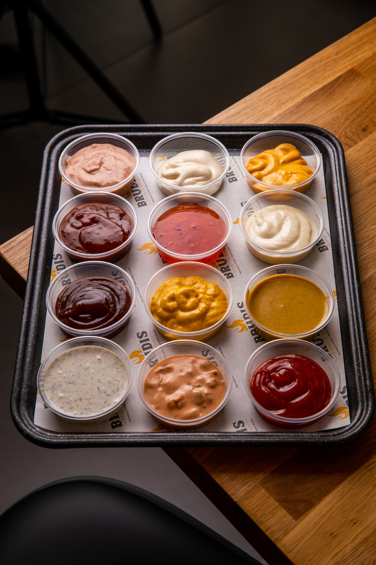 Tray of Brudis house-made sauces in individual pots including garlic, chilli, curry, cocktail, Joppie and chilli cheese